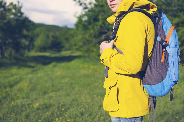 A fiatalember backpack túrázás oldalnézete  - Fotó, kép