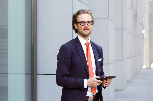 Half length portrait of young businessman, male manager with a tablet pc outdoor near the office - Foto, imagen