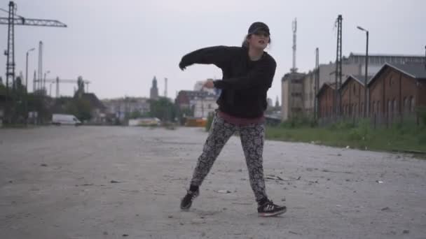 Baile femenino joven activo sobre un fondo industrial
. - Metraje, vídeo