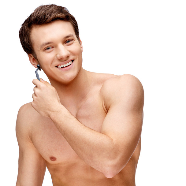 Handsome young man sniffing his armpit - Photo, image