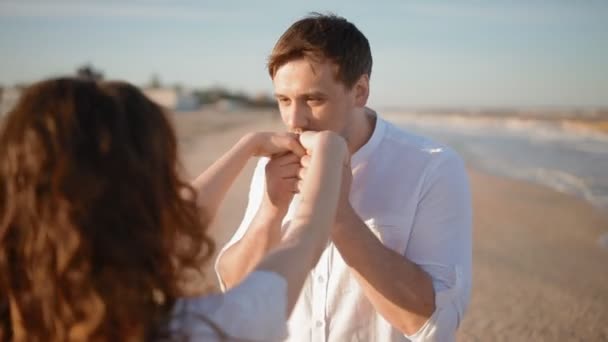 Νεαρός άνδρας φιλί τα χέρια της γυναίκας του στην παραλία - Πλάνα, βίντεο