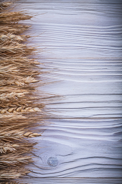 Stack of wheat rye ears on wooden board copy space food and drin - 写真・画像