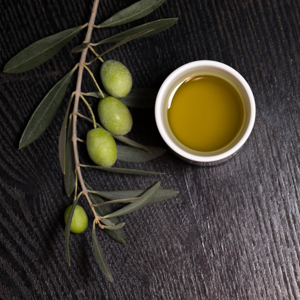 Branch of olive tree with green olive berries and cap of fresh o - 写真・画像