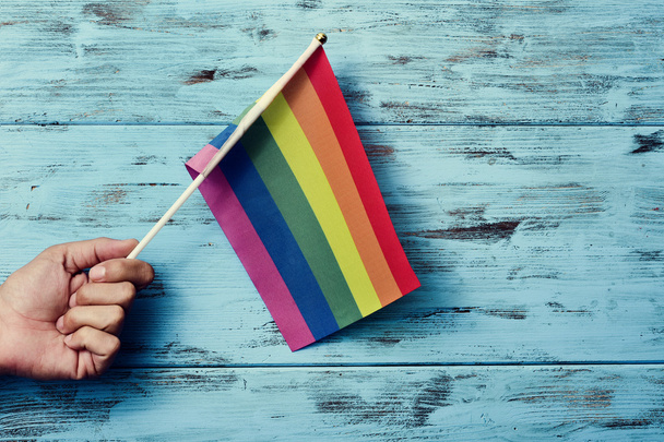 homem acenando uma pequena bandeira do arco-íris
 - Foto, Imagem