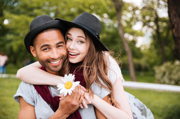 Веселая молодая пара обнимается и улыбается в парке
 - Фото, изображение