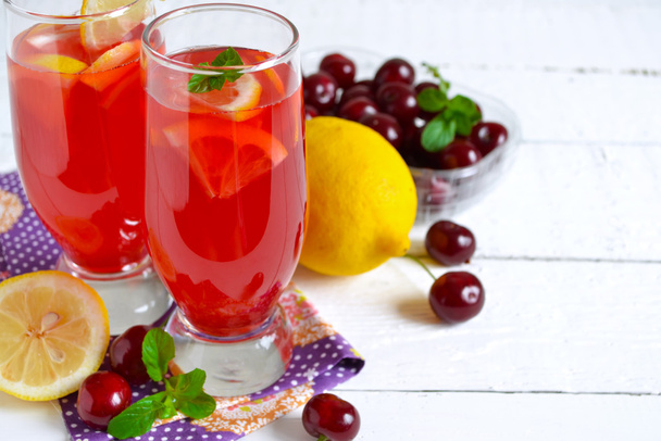 Summer cold drink - lemonade with a cherry on a white background - Foto, afbeelding