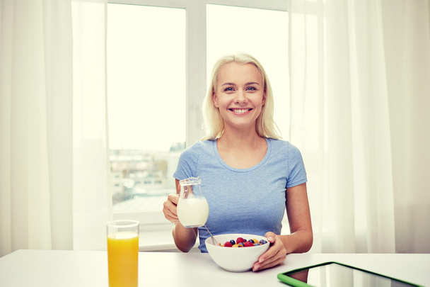 vrouw met melk en cornflakes ontbijt eten - Foto, afbeelding