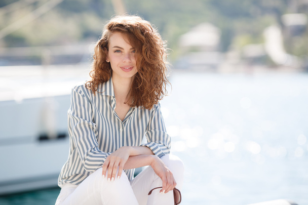 Beautiful girl on the pier next to the yacht club - Valokuva, kuva