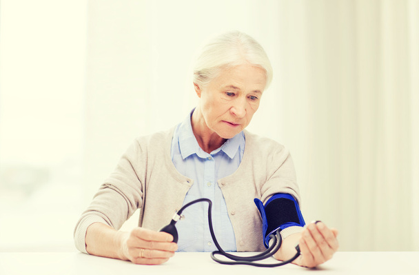 old woman with tonometer checking blood pressure - Zdjęcie, obraz