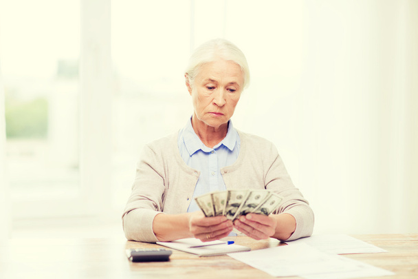 senior woman with money and papers at home - Photo, Image