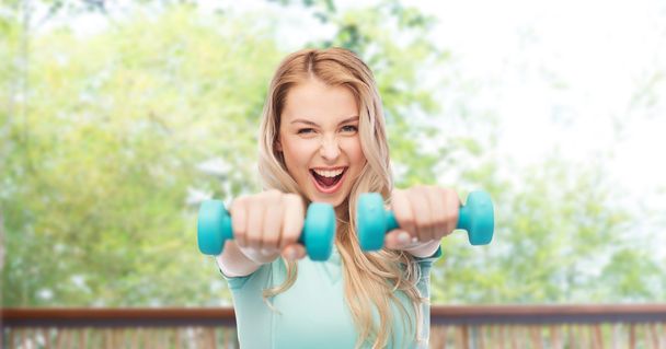 smiling beautiful young sporty woman with dumbbell - Foto, imagen