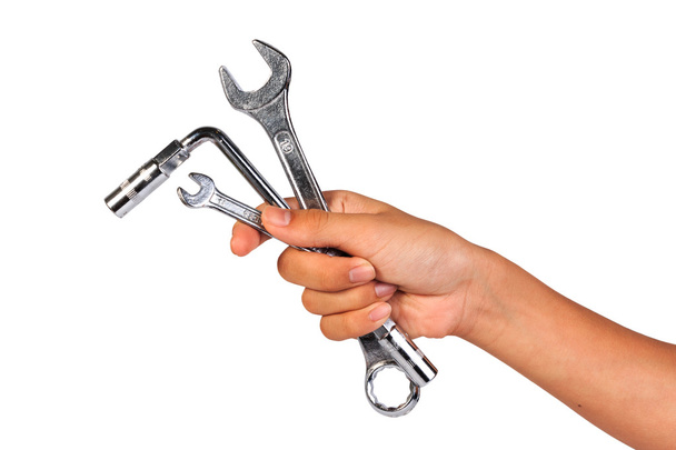 Junge Hand hält einen Schraubenschlüssel isoliert auf einem weißen. Schraubenschlüssel oder Schlüssel halten. - Foto, Bild