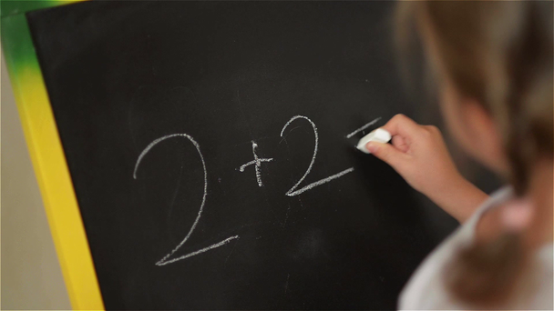 Schoolchild Practicing simple math on chalk board - Footage, Video
