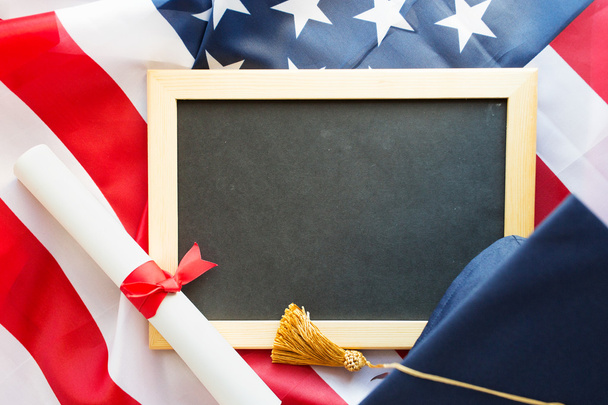 board, bachelor hat and diploma on american flag - Фото, зображення