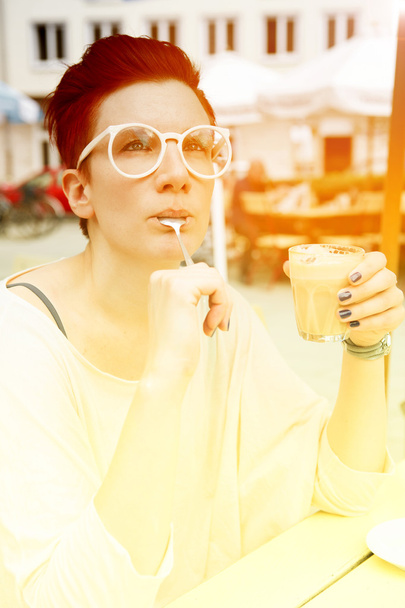 woman sitting outside and drinking coffee - Fotoğraf, Görsel