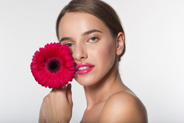 Young girl with flawless skin and red flower - Foto, Imagem