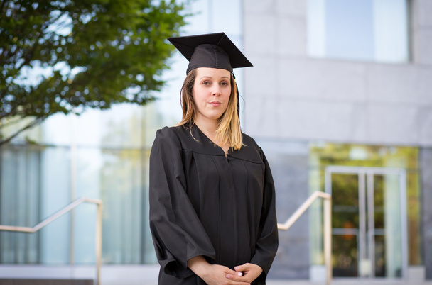 Retrato de estudante universitário do sexo feminino em boné de graduação e vestido em
 - Foto, Imagem