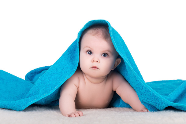 baby child with big eyes under blue towel - 写真・画像