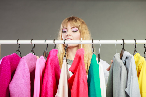 Pretty woman looking at clothes. - 写真・画像