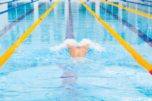 dynamic and fit swimmer in cap breathing performing the butterfly stroke - Fotografie, Obrázek