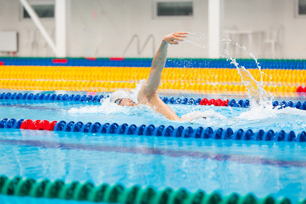 Man swimmer swimming crawl in blue water. - Foto, afbeelding