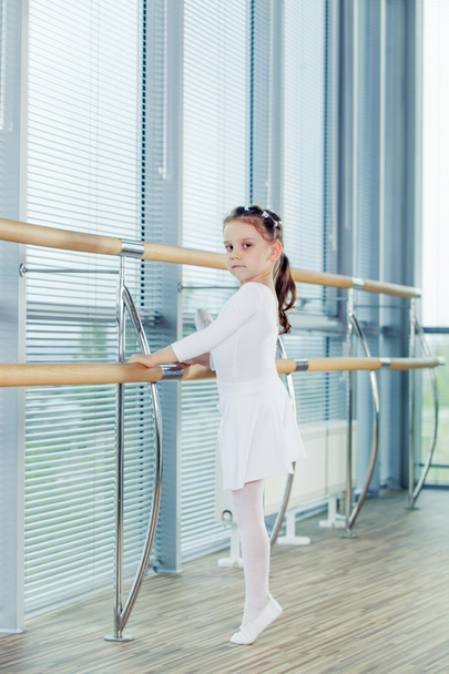 Little ballerina girl. Adorable child dancing classical ballet in a white studio. - Foto, Bild