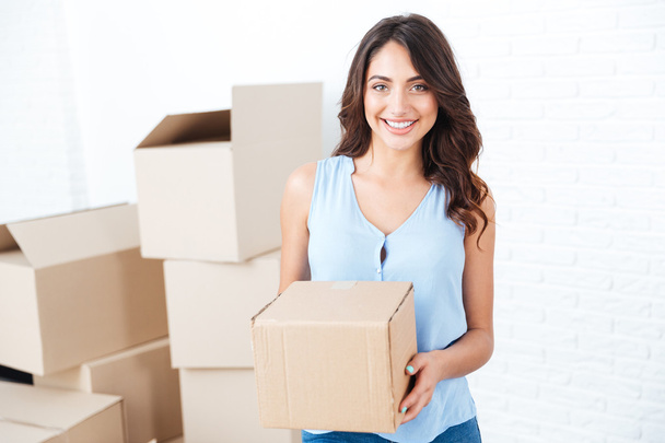Happy woman moving in carrying carton boxes - Photo, Image