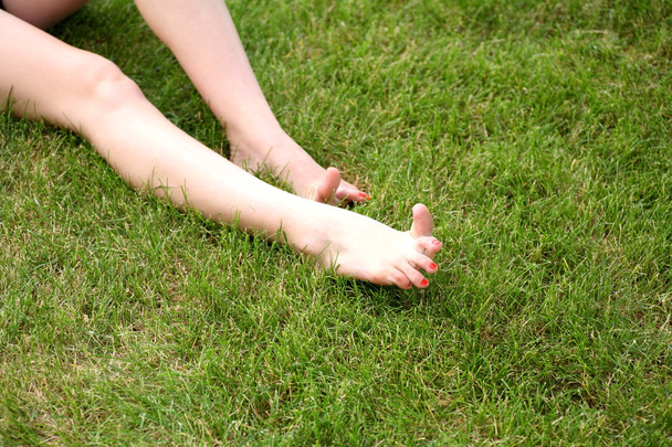 Womans bare feet on green grass - Fotó, kép