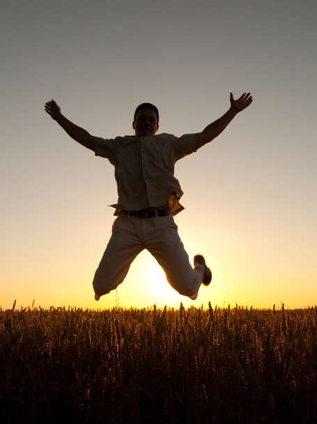 Молодий чоловік стрибає високо в повітрі в сонячний літній день
 - Фото, зображення
