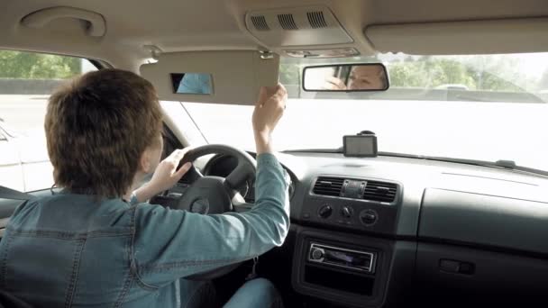 Γυναίκα διορθώνει μακιγιάζ σε έναν καθρέφτη γείσο ήλιων αυτοκινήτων - Πλάνα, βίντεο
