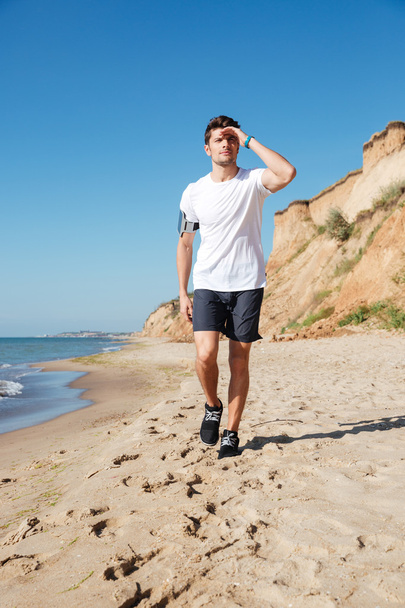 Спортсмен ходить уздовж пляжу
 - Фото, зображення