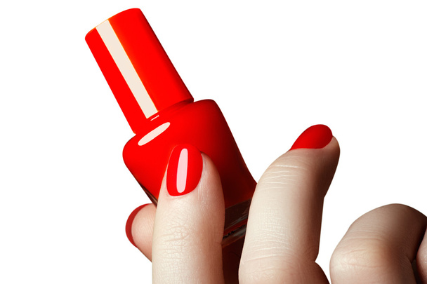 Manicure. Beautiful manicured woman's hands with red nail polish. Beautiful red manicure. Bottle of nail polish. Beauty salon. Hand. Trendy red nails. Nailpolish - 写真・画像