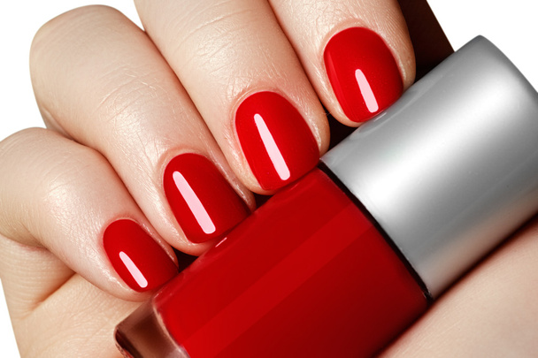 Manicure. Beautiful manicured woman's hands with red nail polish. Beautiful red manicure. Bottle of nail polish. Beauty salon. Hand. Trendy red nails. Nailpolish - Photo, Image
