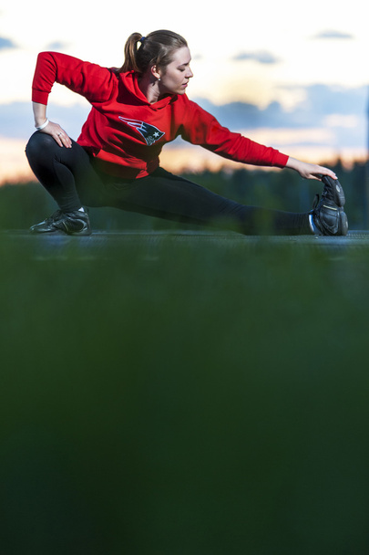 Sporty woman stretching her legs after workout - 写真・画像