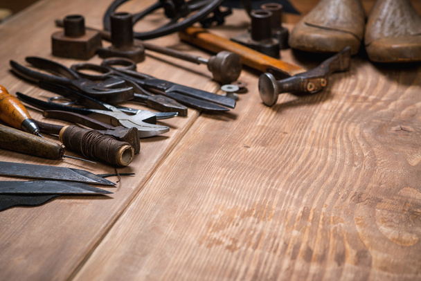 Set of tools for shoemaker on wooden background. Copy space. - Фото, изображение