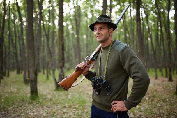 Hunter with shotgun in the forest - Фото, зображення