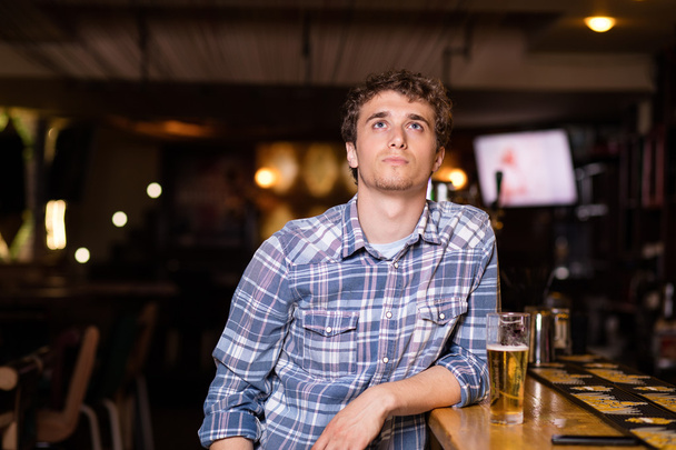 single man sitting at bar having a beer - Фото, изображение