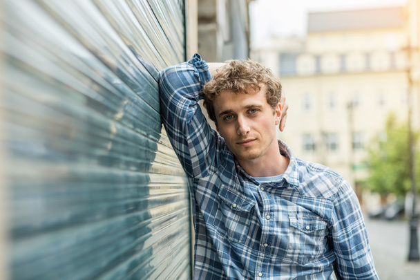 young man in checkered shirt standing outside - Foto, afbeelding