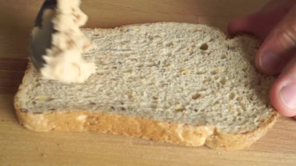Man spreading butter on a bread slice close up shot - Felvétel, videó