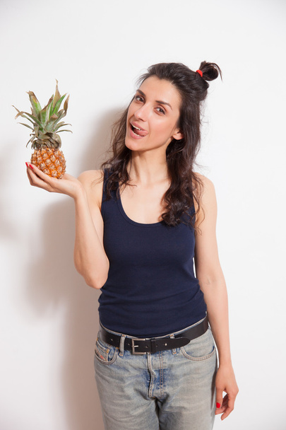 Mujer joven sosteniendo piña - foto de primer plano. Concepto de dieta vegetariana, ingredientes de alimentos crudos, vida sana y alegre
 - Foto, Imagen