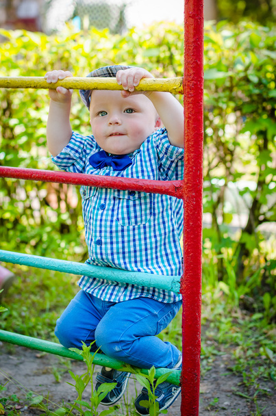 Маленький хлопчик розважається на дитячому майданчику
 - Фото, зображення