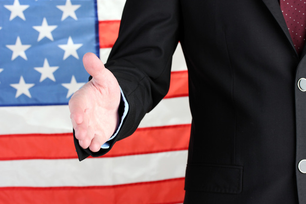 Businessman giving his hand for a handshake on American flag background - Foto, Imagen