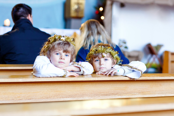 Dos niños pequeños jugando un ángel de la historia de Navidad en la iglesia
 - Foto, imagen