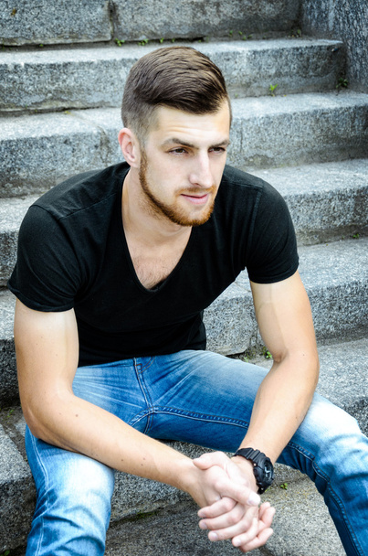Handsome man sitting against wall - Foto, immagini