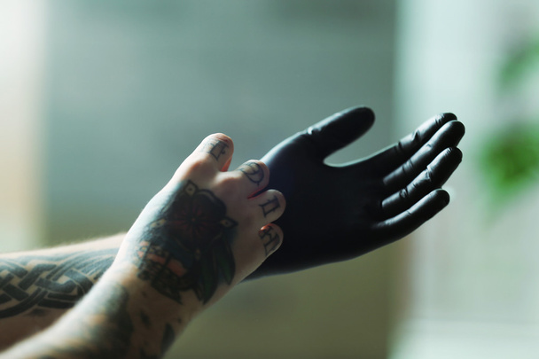 Hombre con tatuaje usando guantes
   - Foto, imagen