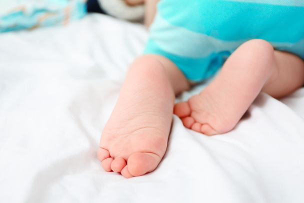 Baby feet on bed - Foto, afbeelding