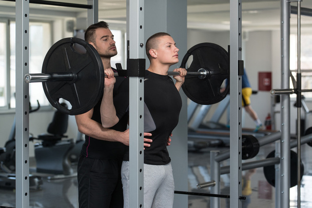 Woman With Personal Trainer At Barbell Squat - Foto, Imagem