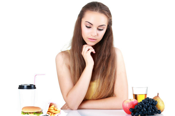 Young doubting girl with apple and hamburger isolated - Photo, Image