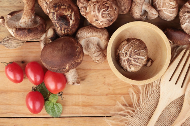 Shiitake mushrooms for cooking on wood background - 写真・画像