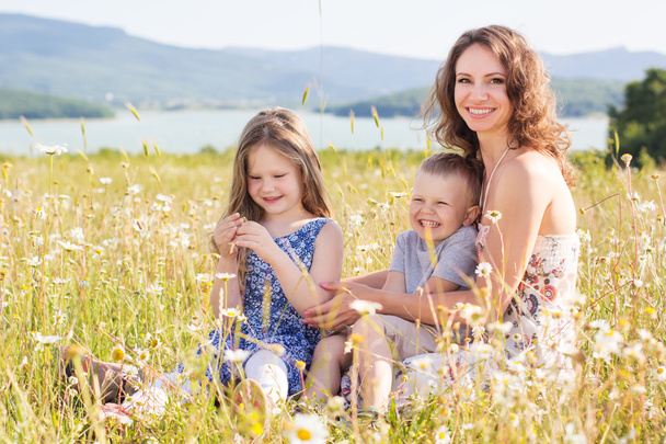 Matka, dziewczyna i chłopak w pole rumianek - Zdjęcie, obraz